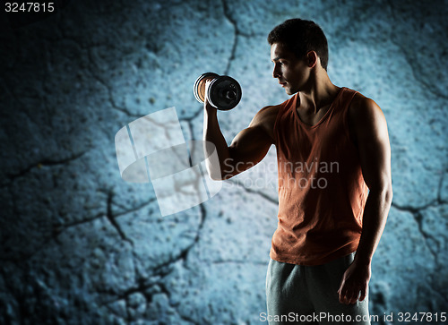 Image of young man with dumbbell flexing biceps