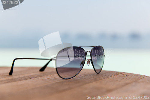 Image of shades or sunglasses on table at beach