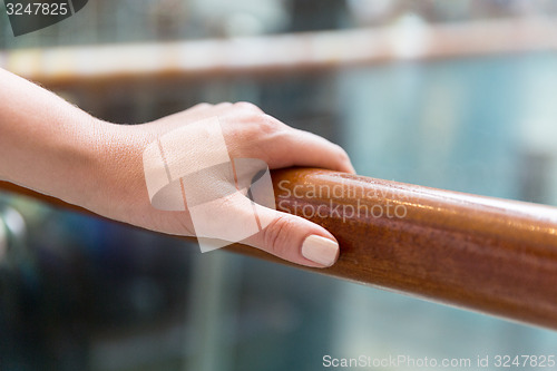 Image of close up of woman hand holding to railing