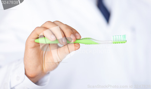 Image of dentist or stomatologist holding toothbrush