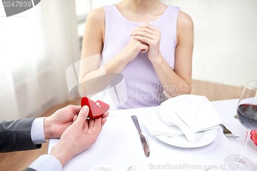 Image of excited young woman and boyfriend giving her ring