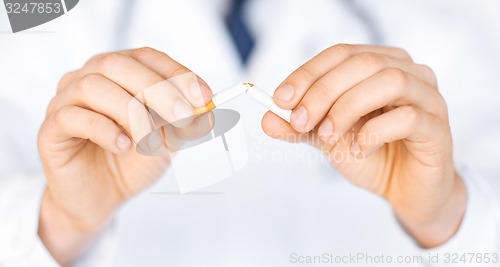 Image of man breaking the cigarette with hands