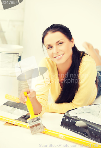 Image of woman with paintbrush and renovating tools