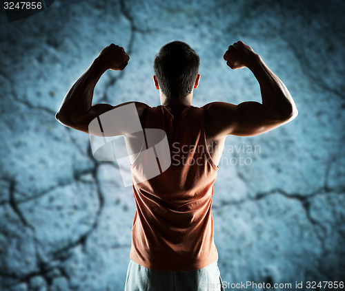 Image of young man or bodybuilder showing biceps