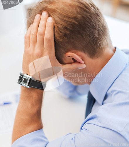 Image of stressed businessman at work