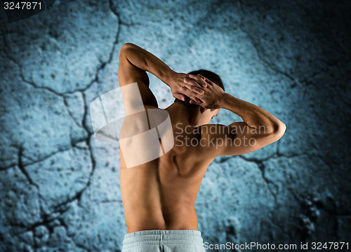 Image of young man or bodybuilder showing muscles