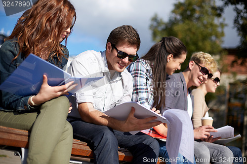 Image of group of happy students with notebooks at campus