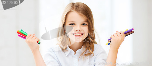 Image of smiling girl showing colorful felt-tip pens