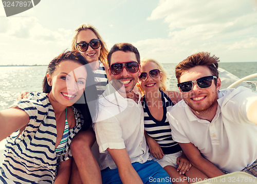 Image of smiling friends sitting on yacht deck