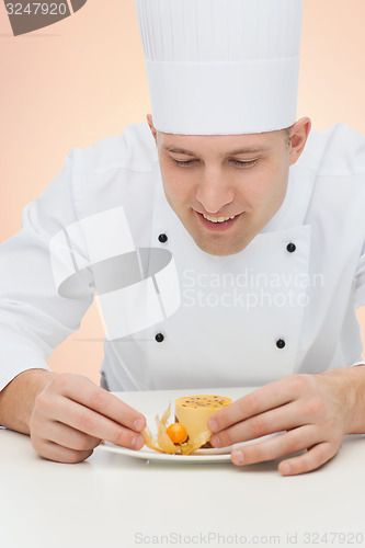 Image of happy male chef cook decorating dessert