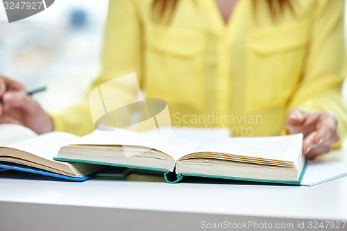 Image of close up of female hands to book or textbook