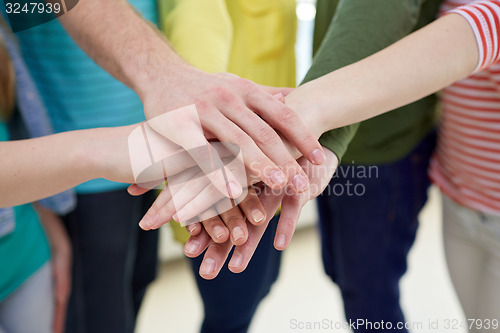 Image of close up of students or friends with hands on top
