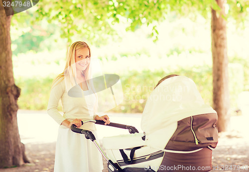 Image of happy mother with stroller in park