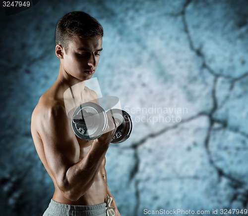 Image of young man with dumbbell flexing biceps