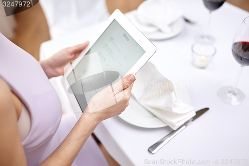 Image of close up of woman with tablet pc at restaurant