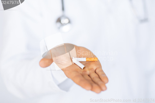 Image of man breaking the cigarette with hands