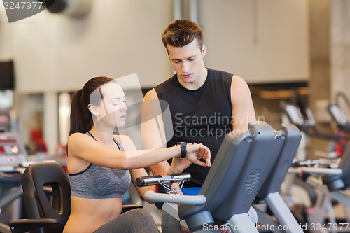 Image of woman with trainer on exercise bike in gym