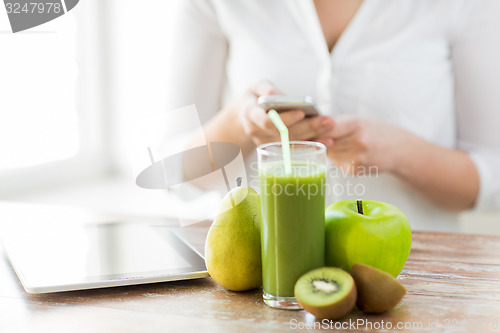 Image of close up of woman with smartphone and fruits