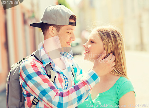 Image of smiling couple with backpack in city