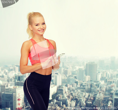 Image of smiling sporty woman with smartphone