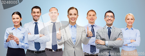 Image of group of happy businesspeople showing thumbs up