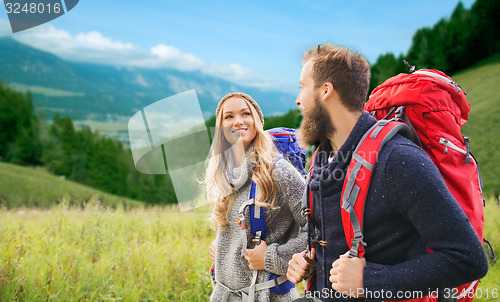 Image of smiling couple with backpacks hiking