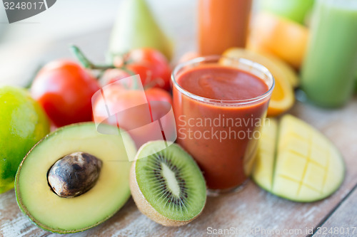 Image of close up of fresh juice glass and fruits on table