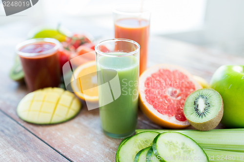 Image of close up of fresh juice glass and fruits on table