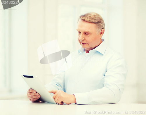 Image of old man with tablet computer at home