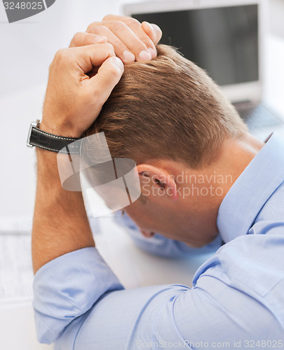 Image of stressed businessman at work