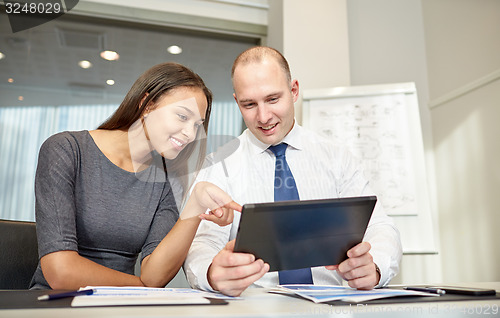 Image of smiling businesspeople with tablet pc in office