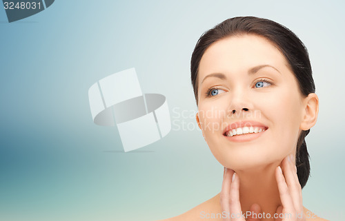 Image of beautiful young woman touching her face and neck