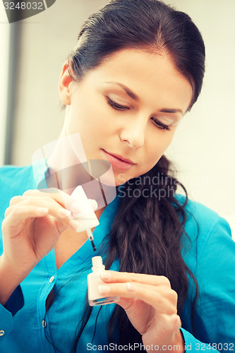 Image of beautiful woman polishing her nails