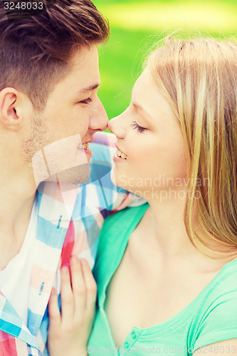 Image of smiling couple touching noses in park