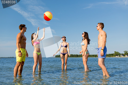 Image of smiling friends in sunglasses on summer beach