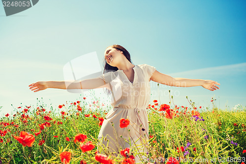 Image of smiling young woman on poppy field