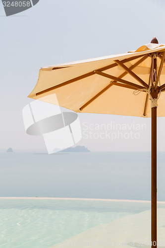 Image of view from infinity edge pool with parasol to sea