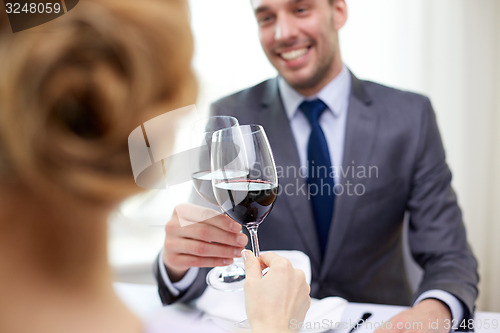 Image of happy couple with glasses of wine at restaurant