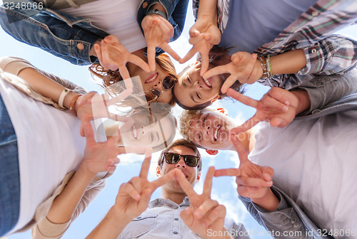 Image of group of teenagers showing finger five