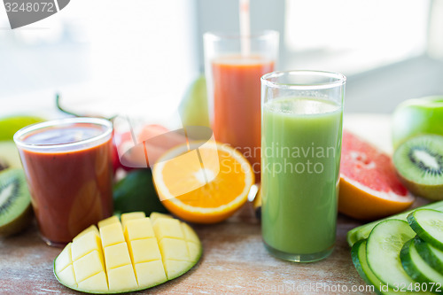 Image of close up of fresh juice glass and fruits on table