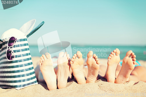 Image of three women lying on the beach