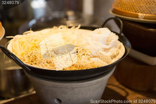 Image of bowl of rice noodles garnish at asian restaurant