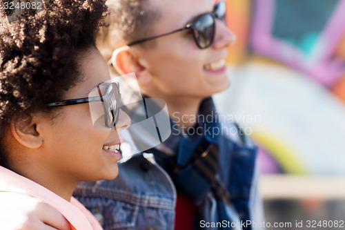 Image of happy teenage friends in shades outdoors