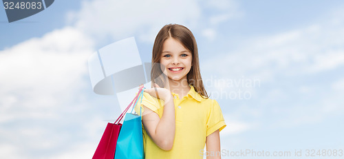 Image of smiling little girl in dress with shopping bags