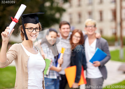 Image of happy teenage students with diploma and folders