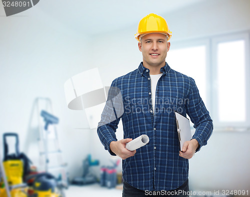 Image of smiling male builder in helmet with blueprint