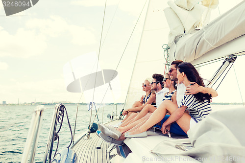 Image of smiling friends sitting on yacht deck