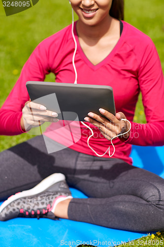 Image of close up of smiling woman with tablet pc outdoors