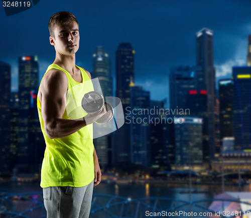 Image of young man with dumbbell flexing biceps