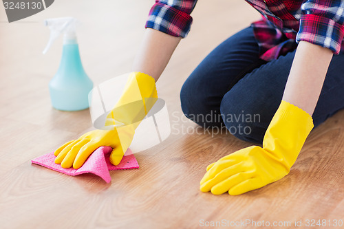 Image of close up of woman with rag cleaning floor at home